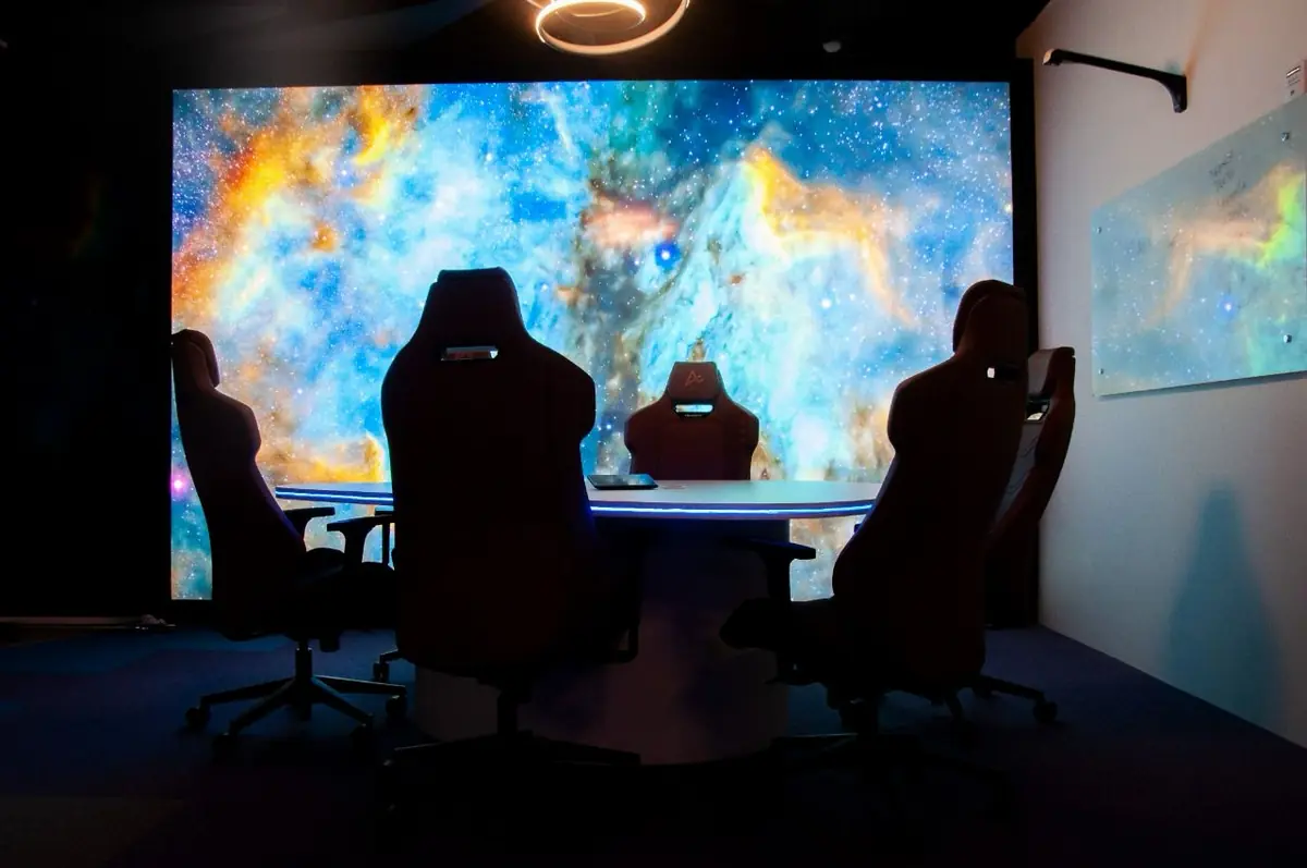 O painel iluminado com a imagem de espaço, na parede principal da Sala 09